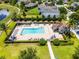 Overhead view of the community pool with lounge chairs, tables, landscaping and a lake in a residential area at 251 Domus Ln, Casselberry, FL 32707