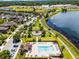 Aerial view of a community pool and playground area near a lake with walking trails, and houses nearby at 251 Domus Ln, Casselberry, FL 32707