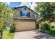 Charming two-story home with a two car garage and a brick driveway, surrounded by mature trees and landscaping at 251 Domus Ln, Casselberry, FL 32707