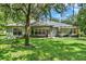 Spacious backyard with a covered patio, outdoor furniture, and lush greenery for outdoor relaxation and entertainment at 2563 Breezy Meadow Rd, Apopka, FL 32712