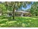 Large backyard with shaded patio, outdoor seating, and well-manicured lawn offering an ideal outdoor living space at 2563 Breezy Meadow Rd, Apopka, FL 32712
