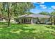 Expansive backyard featuring a covered patio, outdoor seating, and a well-maintained lawn for outdoor enjoyment at 2563 Breezy Meadow Rd, Apopka, FL 32712
