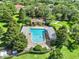 Aerial view of a sparkling community pool surrounded by lush landscaping, offering a refreshing retreat at 2563 Breezy Meadow Rd, Apopka, FL 32712