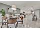Bright dining area with modern table and chairs adjacent to an updated kitchen featuring white cabinets at 2563 Breezy Meadow Rd, Apopka, FL 32712