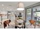 Well-lit dining area with a modern glass table and chairs, leading to a patio and open-concept kitchen at 2563 Breezy Meadow Rd, Apopka, FL 32712