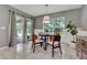 Cozy dining area with a round glass table, stylish chairs, and large windows at 2563 Breezy Meadow Rd, Apopka, FL 32712