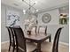 Dining room with contemporary chandelier, artwork, and a view into the next room at 2563 Breezy Meadow Rd, Apopka, FL 32712