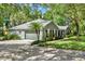 A single story home with a two car garage, well manicured shrubs and tropical landscaping at 2563 Breezy Meadow Rd, Apopka, FL 32712