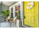Inviting front porch featuring a yellow front door, seating and decorative plants at 2563 Breezy Meadow Rd, Apopka, FL 32712