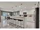 Stylish kitchen features white cabinetry, stainless steel appliances, and a breakfast bar at 2563 Breezy Meadow Rd, Apopka, FL 32712