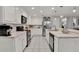 Well-equipped kitchen featuring white cabinets, a stainless steel refrigerator, and modern appliances at 2563 Breezy Meadow Rd, Apopka, FL 32712