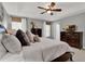 Comfortable primary bedroom with a ceiling fan, two windows, and dark wood furniture at 2563 Breezy Meadow Rd, Apopka, FL 32712