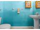 Bathroom with a pedestal sink, toilet, and colorful blue walls at 2850 Spring Heather Pl, Oviedo, FL 32766