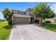 Inviting home with a brick driveway, lovely landscaping, an American flag, and a convenient two-car garage at 2850 Spring Heather Pl, Oviedo, FL 32766