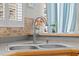 Close up shot of the kitchen sink featuring a gooseneck faucet and a window overlooking the backyard at 2850 Spring Heather Pl, Oviedo, FL 32766