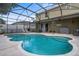 Backyard pool with lounge chairs and ample seating under a screened-in enclosure at 2850 Spring Heather Pl, Oviedo, FL 32766