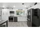 Contemporary kitchen featuring stainless appliances, white cabinetry, modern fixtures, and plank flooring at 2908 Clear Way, Orlando, FL 32805