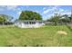 Lush backyard with expansive lawn featuring mature trees, and partial fencing for privacy at 323 Scotland Dr, Daytona Beach, FL 32117