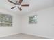 Bright bedroom featuring tile floors, a ceiling fan, and two windows at 323 Scotland Dr, Daytona Beach, FL 32117