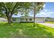Charming single-story home with lush green lawn and mature trees creating a welcoming curb appeal at 323 Scotland Dr, Daytona Beach, FL 32117