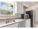 Kitchen corner with stainless steel sink, stainless steel refrigerator, and white cabinetry at 323 Scotland Dr, Daytona Beach, FL 32117