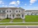 Charming two-story townhome with well-manicured lawn and inviting entryway, under a bright sky at 3231 Gardenia Reserve St, Apopka, FL 32712
