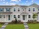 Charming townhome with well-manicured lawn, complemented by a welcoming walkway and vibrant green door at 3235 Gardenia Reserve St, Apopka, FL 32712