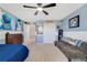 Blue accent wall with posters and decor in this cozy bedroom, ceiling fan, and white trim at 352 Giovani Blvd, Clermont, FL 34715