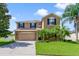 Beautiful two-story home with lush landscaping, attached two-car garage, and inviting curb appeal at 352 Giovani Blvd, Clermont, FL 34715