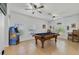 Well-lit game room featuring a pool table, arcade game, and two large windows, ideal for recreation at 352 Giovani Blvd, Clermont, FL 34715