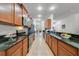 Long galley kitchen featuring granite countertops, stainless steel appliances, and tiled floors for a modern look at 352 Giovani Blvd, Clermont, FL 34715
