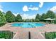 Community pool with brick patio, umbrellas, and families enjoying a swim on a sunny day at 352 Giovani Blvd, Clermont, FL 34715