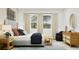 Stylish bedroom showcasing a gray upholstered bed, natural wood furniture, and two windows with natural light at 367 Sol Vista Dr, Dundee, FL 33838