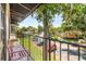 Overlooking a street with parked cars and mature trees, this balcony has a pink bench at 3946 Versailles Dr # 3946B, Orlando, FL 32808