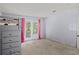 Bright bedroom featuring carpet and doors to a private balcony with pink curtains at 3946 Versailles Dr # 3946B, Orlando, FL 32808