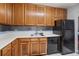 Kitchen showcasing wood cabinets and a black appliance suite with a dishwasher and refrigerator at 3946 Versailles Dr # 3946B, Orlando, FL 32808