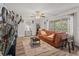 Comfortable living room with wood flooring, sliding glass doors, and orange couch, plus a decorative area rug at 3946 Versailles Dr # 3946B, Orlando, FL 32808