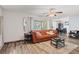 Cozy living room featuring wood flooring, sliding glass doors, and an orange couch with neutral pillows at 3946 Versailles Dr # 3946B, Orlando, FL 32808