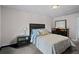Well-lit bedroom showcasing carpet flooring, a large bed with tufted headboard, and matching black furniture at 3946 Versailles Dr # 3946B, Orlando, FL 32808