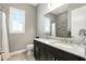 Bathroom features a double vanity with granite countertop and dark cabinets, complemented by a window with white shutters at 3995 Equine Cv, Lake Mary, FL 32746