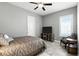 Bright bedroom with a ceiling fan, plush chair, and large window with an outdoor view at 3995 Equine Cv, Lake Mary, FL 32746