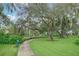 Scenic walking path in the common area, lined with mature trees and lush greenery at 3995 Equine Cv, Lake Mary, FL 32746