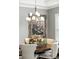 Close-up of a dining room highlighting the chandelier, decor, and furniture with window views at 3995 Equine Cv, Lake Mary, FL 32746