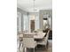 Elegant dining room features a modern chandelier, neutral color palette, and seating for six at 3995 Equine Cv, Lake Mary, FL 32746