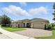 Well-manicured lawn and a spacious driveway leading to a home with multiple garage doors, and a charming tile roof at 3995 Equine Cv, Lake Mary, FL 32746