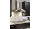 Contemporary kitchen featuring a modern range hood, gas cooktop, and dark cabinetry at 3995 Equine Cv, Lake Mary, FL 32746