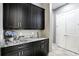 Laundry room with modern black cabinets and a marble countertop, complemented by a dual closet at 3995 Equine Cv, Lake Mary, FL 32746