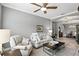 Cozy living room featuring a comfortable sofa, ceiling fan, and elegant decor with view to dining room at 3995 Equine Cv, Lake Mary, FL 32746