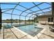 Covered pool area overlooking the lake is perfect for outdoor lounging with an extended brick paver patio at 3995 Equine Cv, Lake Mary, FL 32746