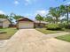 Ranch home featuring stone accents, a two car garage, and mature landscaping at 412 Ranch Trl, Casselberry, FL 32707